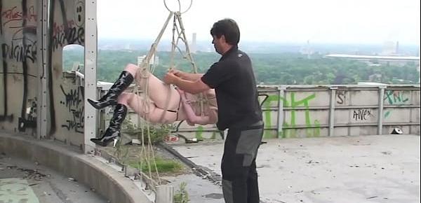 Nackte Sklavin gefesselt im Hängebondage und mit Seilen